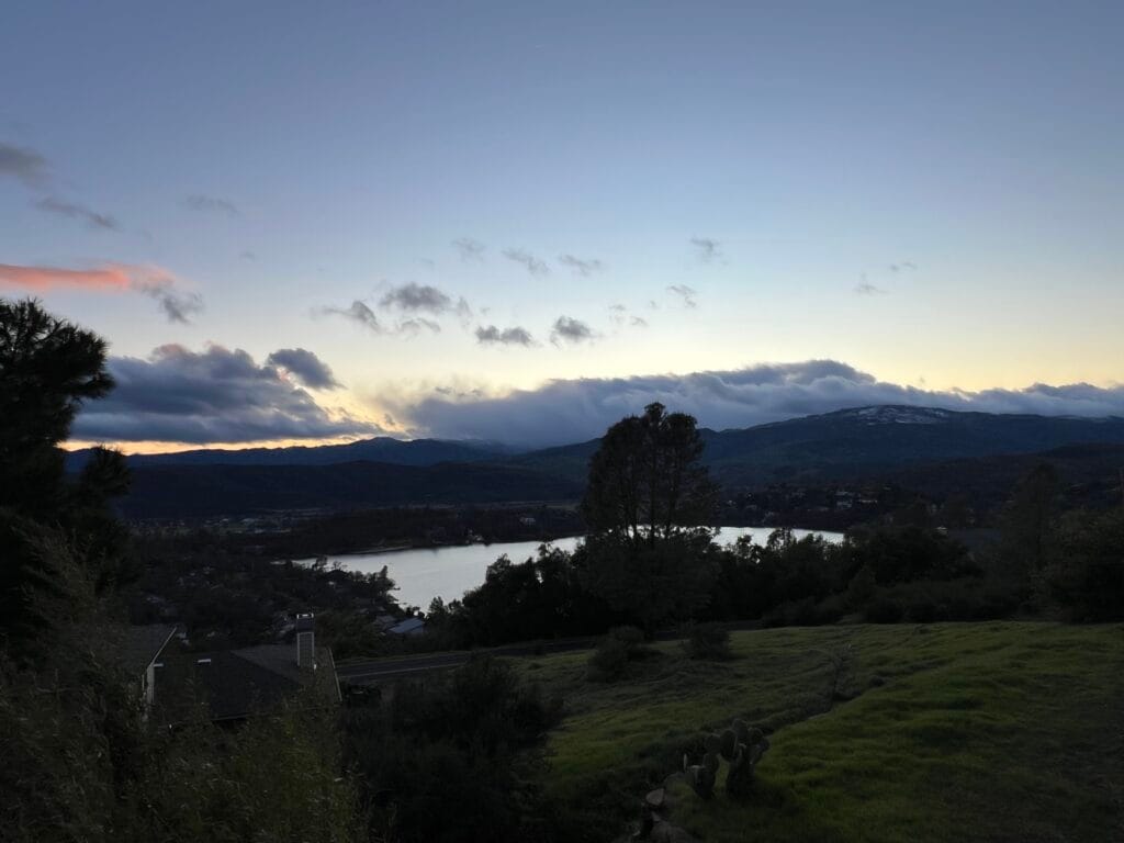 Cinematic view of a luxury USA house overlooking a pristine lake and mountains, representing premium American real estate and investment properties.
