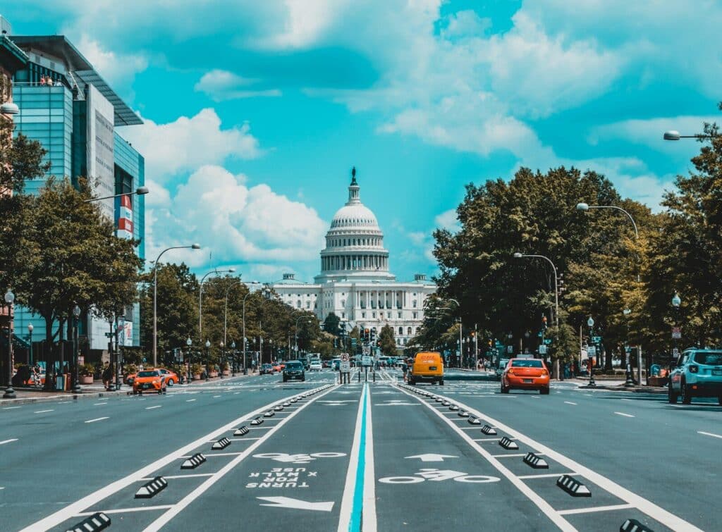 wide road with vehicle traveling with white dome building washington dc