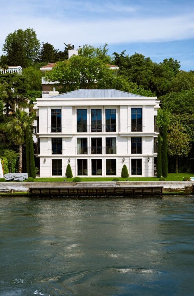 a large white house sitting on top of a lake