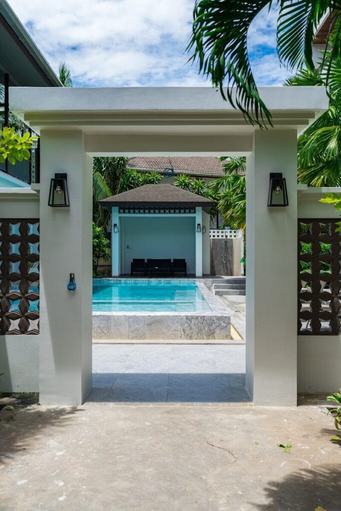 Entrance to a resort pool area with lounge chairs