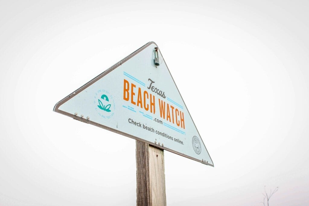 corpus christi real estate in texas has a beach watch sign on top of a wooden pole