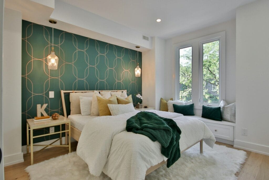 A bedroom with a green wall and a white bed