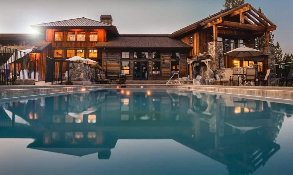 Stunning wooden villa with a large pool and cozy lights, perfect for a luxurious escape. USA Houses