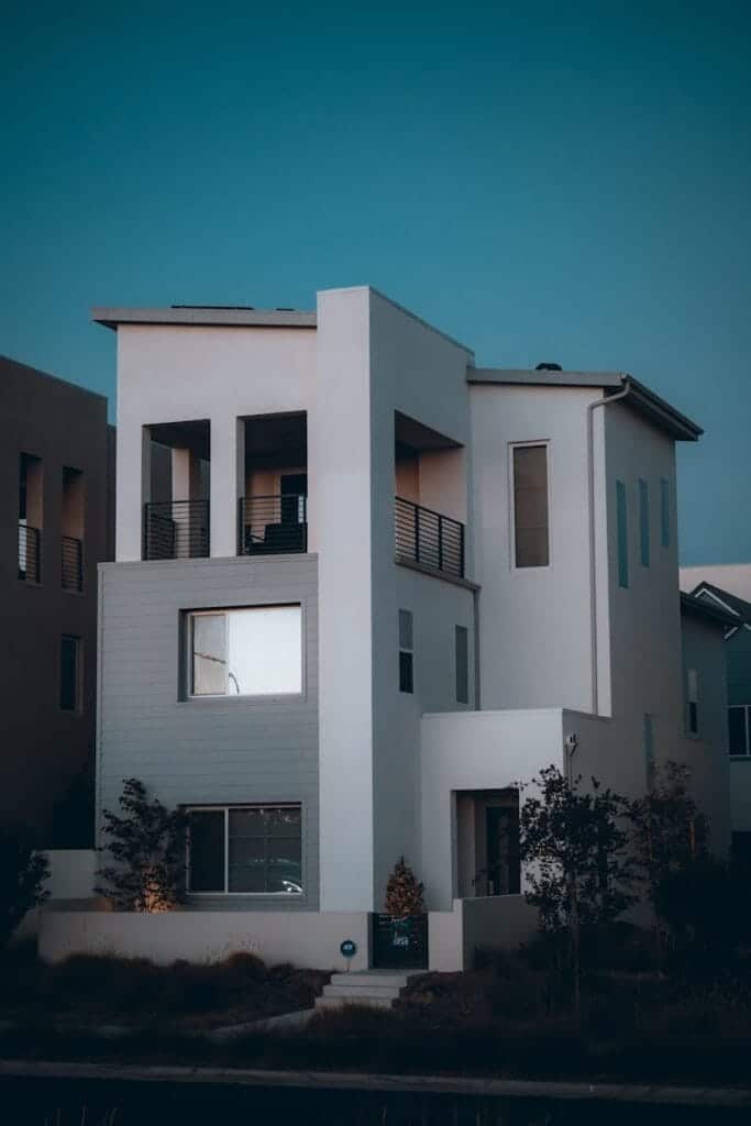 A nice white multi story home with a blue sky in the background