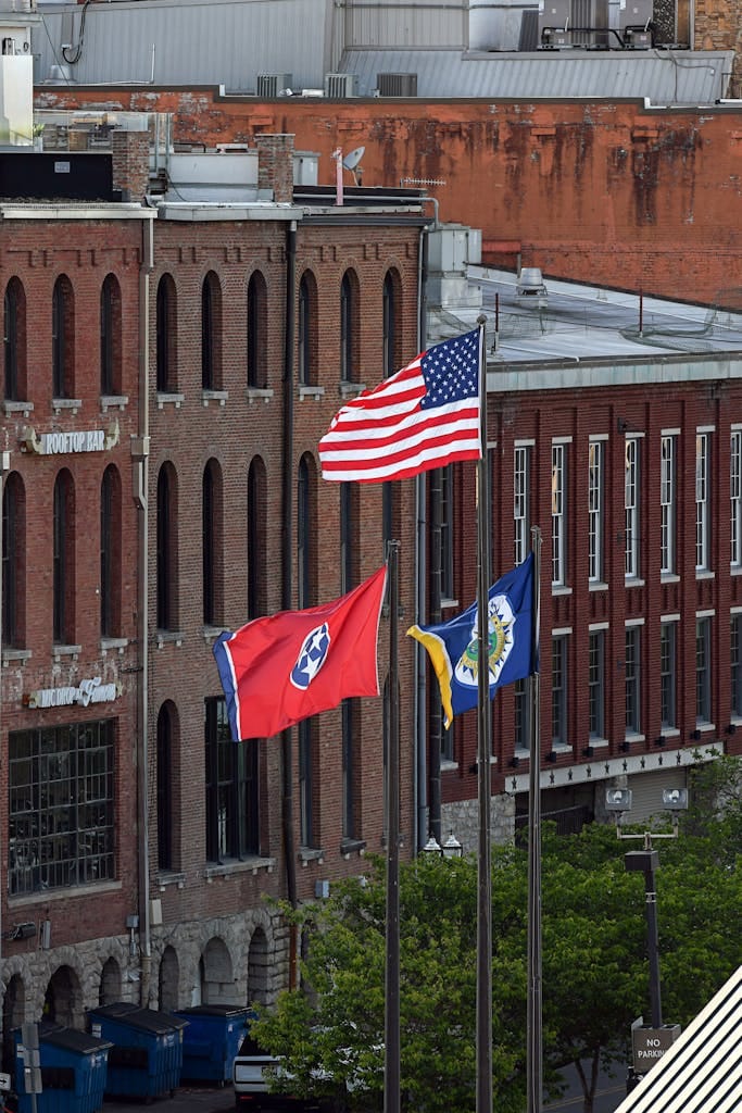 Urban view of American and Tennessee flags displaying in downtown Nashville, TN.