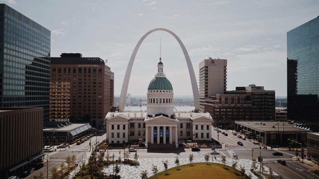 St. Louis real estate like this amazing white and green arch and dome in between high-rise buildings during daytime