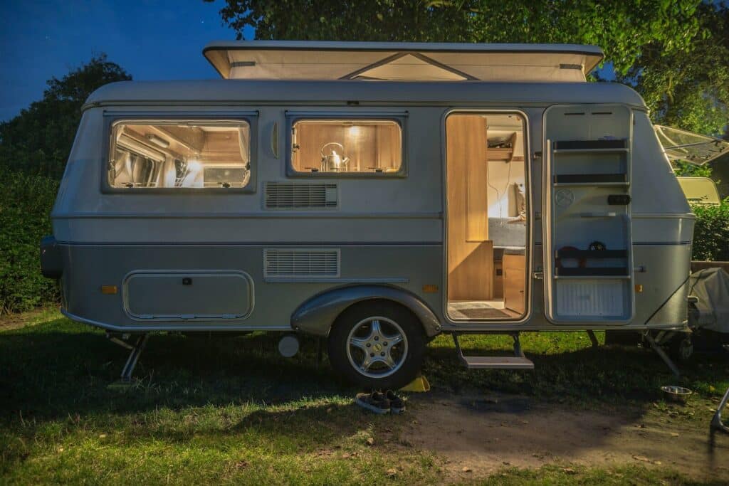 Mobile real estate is not the same as mobile homes like this one. Mobile AL Homes For Sale, differ greatly from this white and brown camper trailer beside tree