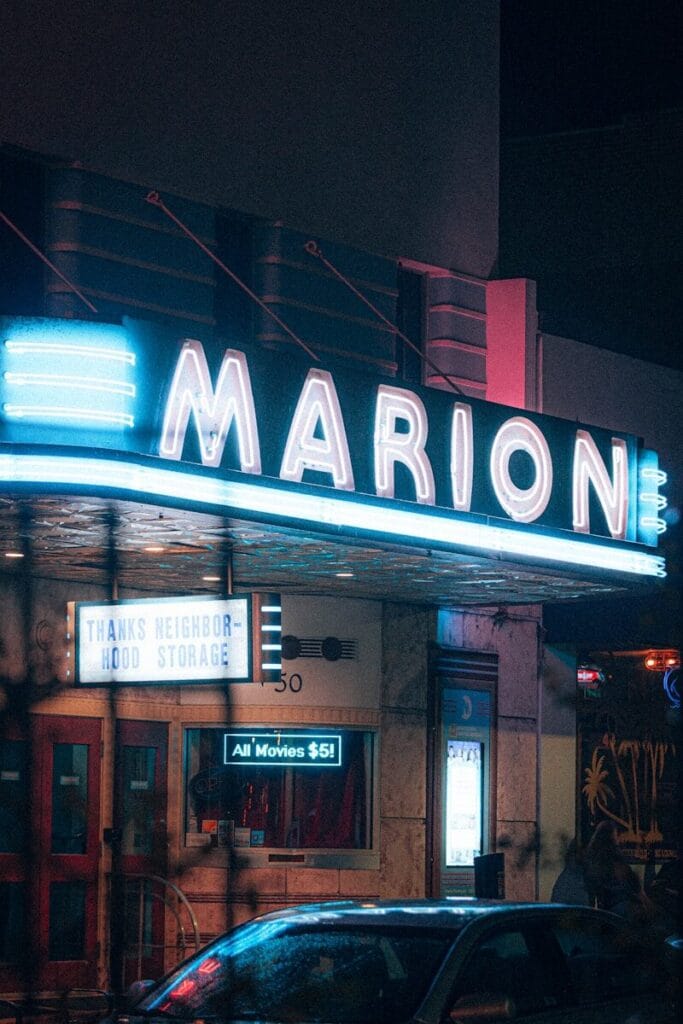 A car parked in front of a marquee at night in Ocala Florida, Marion Theater in Marion County