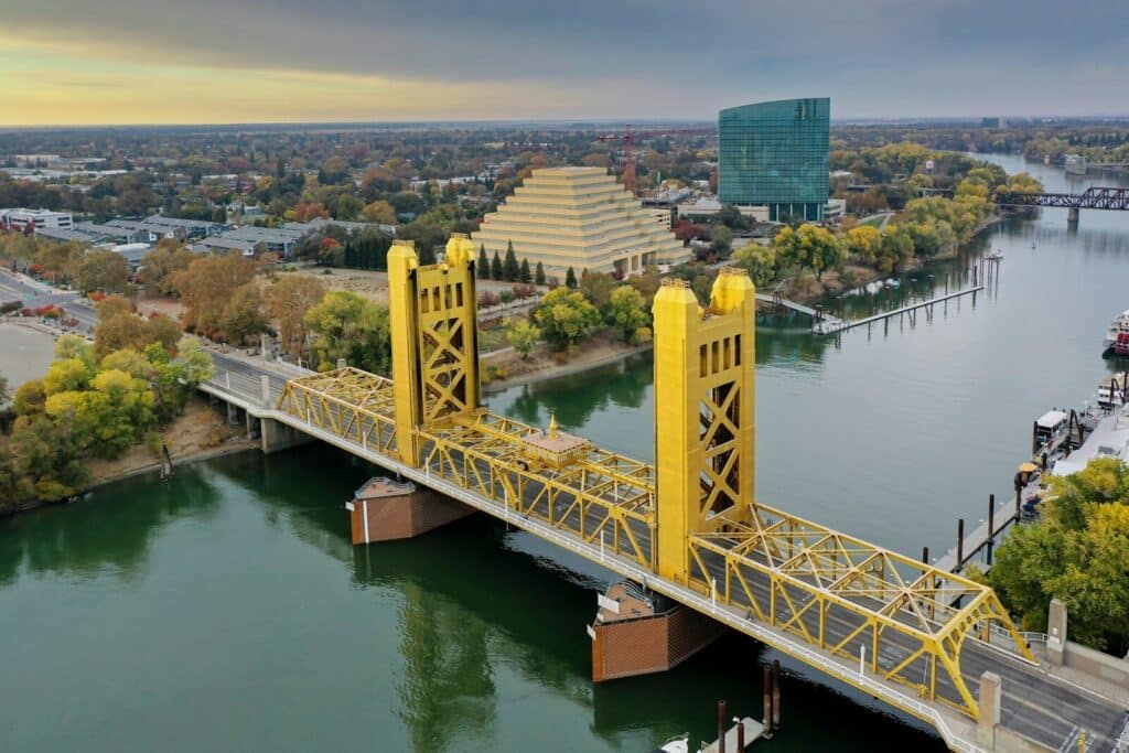 white bridge over river during daytime driving to get some Sacramento Real Estate